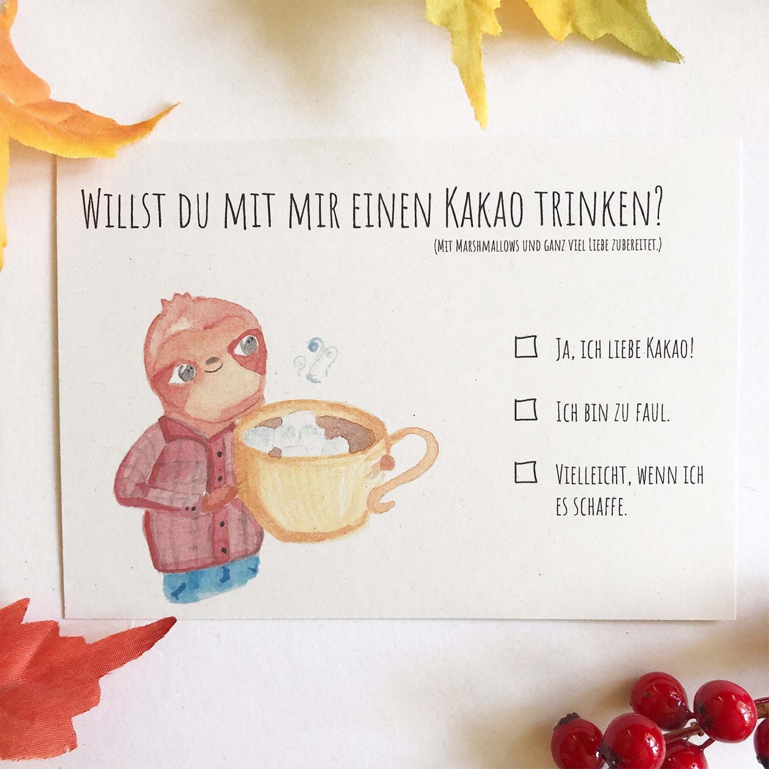 Postkarte mit Faultier und Kakao in der Hand mit Herbstdekoration